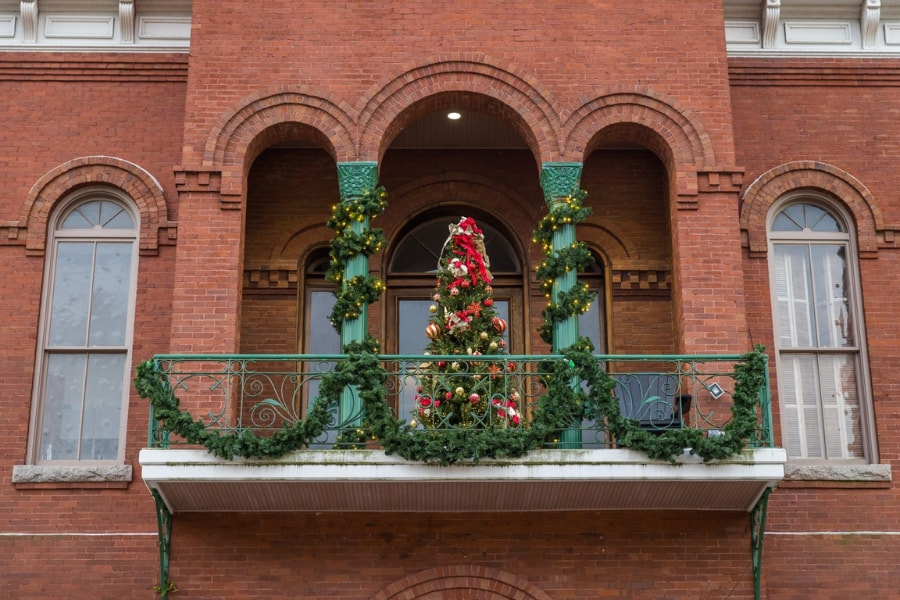 brick building with Christmas tree and garland on front patio