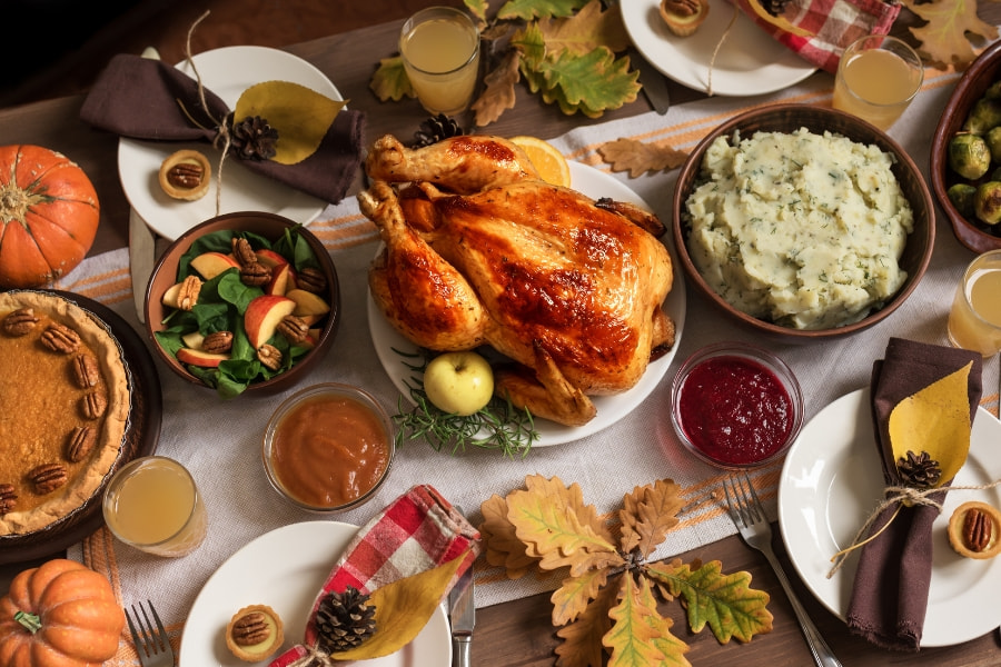 decorated dining room table with Thanksgiving turkey and side dishes