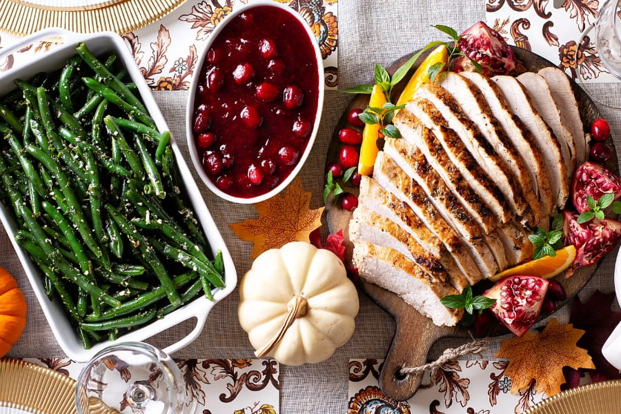 turkey, green beans, cranberry sauce set on a table for a Thanksgiving meal at home 