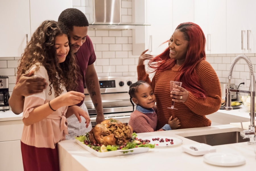 family standing in kitchen at vacation rental for Thanksgiving 