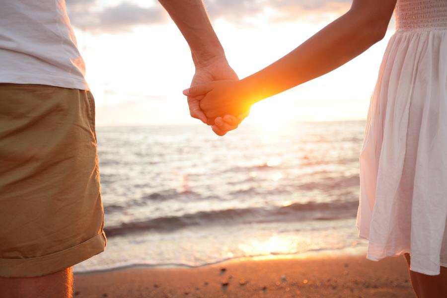 Couple holding hands at the beach in Amelia Island at sunset