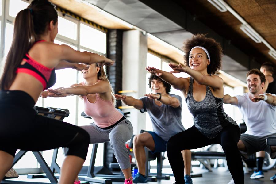 Group of friends working out in a gym during a health and wellness vacation